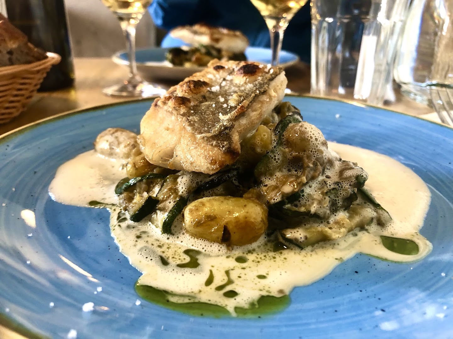 Un poisson servi avec légumes et sauce crémeuse