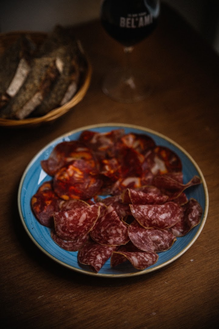 Une assiette de charcuterie avec du pain et une bouteille