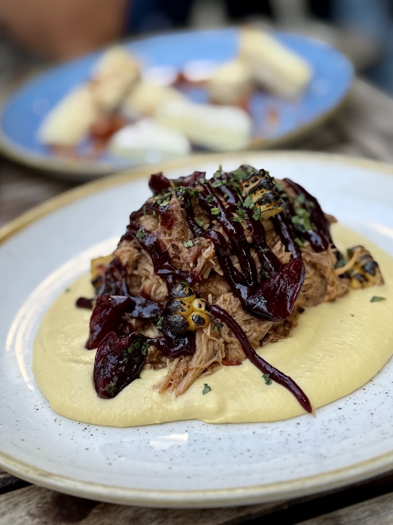 Une viande effilochée avec légumes violets et purée claire